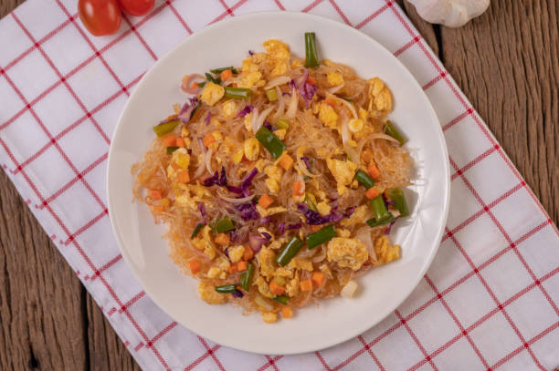 istock Stir fried glass noodles with eggs and put on a plate on a red white cloth. 1433256090