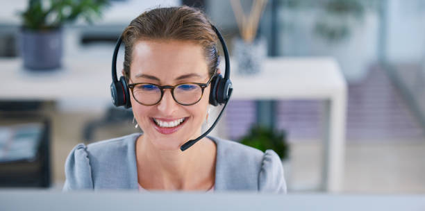 istock Happy, smiling and friendly call center agent or telemarketing operator wearing headset while working in an office. Smile of a sales consultant operating helpdesk for customer and service support 1433257583