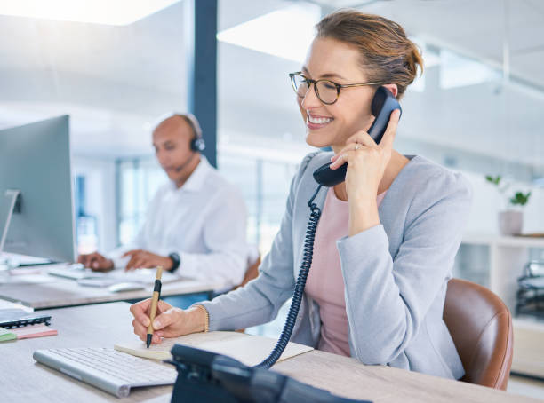 istock Call center operator, marketing agent and sales consultant networking, talking and consulting on telephone. Friendly secretary, business woman and support helpdesk writing notes for customer service 1433257586