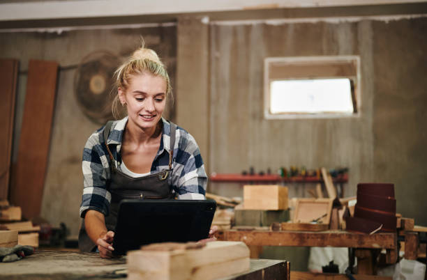 istock Woman carpenter is calculating and drawing woodwork on tablet. 1433259131