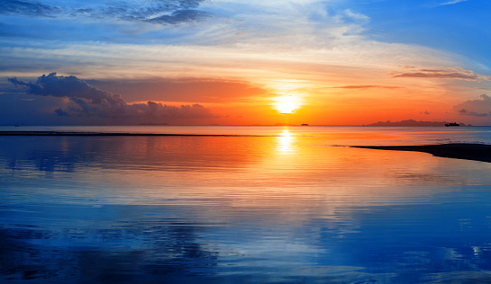 Sea sunset view, colorful ocean sunrise seascape, blue water waves, golden sun glow reflection, red orange sky, clouds, beautiful tropical island beach coast landscape, summer holidays vacation travel