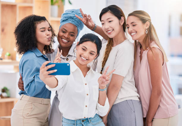 istock Fun, diverse and playful team selfie on phone and having fun, goofing around or making peace sign gesture. Cheerful goofy group of business friends or creative colleagues posing for social media post 1433261362