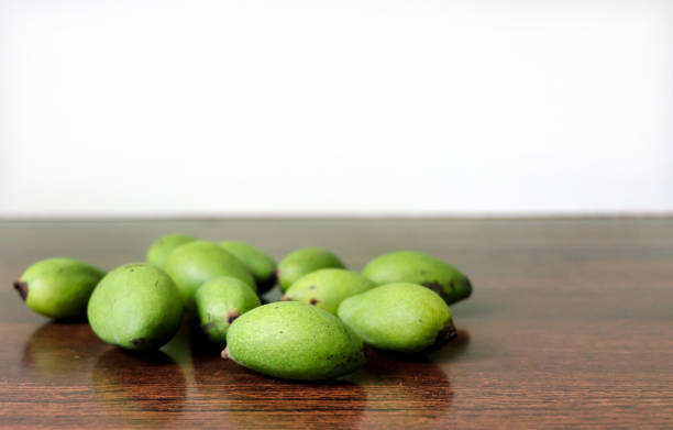 Small green mangoes on a wooden table free space