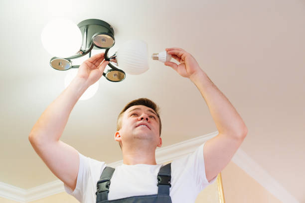 istock A male electrician changes the light bulbs in the ceiling light. 1433265840