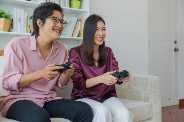 istock Husband and wife enjoy playing console game together at home. 1433266807
