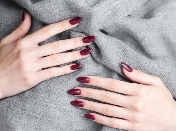 ręce młodej kobiety z ciemnoczerwonym manicure na paznokciach - red nail polish zdjęcia i obrazy z banku zdjęć