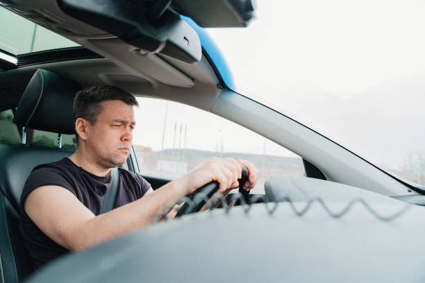 istock a serious and angry man drives a car on the highway 1433271997
