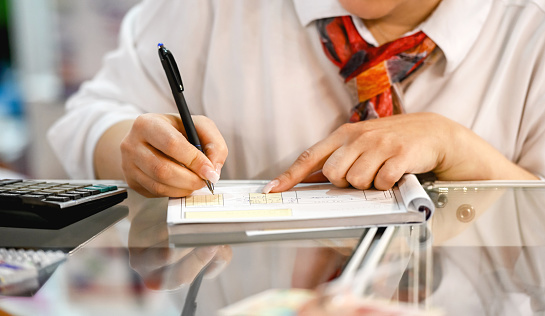 Close-up of saleswoman issuing an invoice, writing