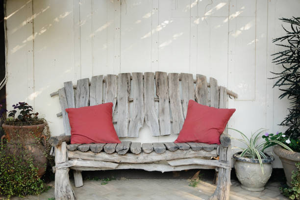 décor de patio extérieur vintage - banc en bois rustique gris, jardinières antiques avec verdure, mur blanc patiné. - weatherd photos et images de collection