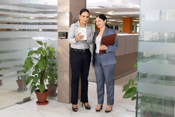 istock Two happy businesswomen discussing using digital tablet at office. 1433281553