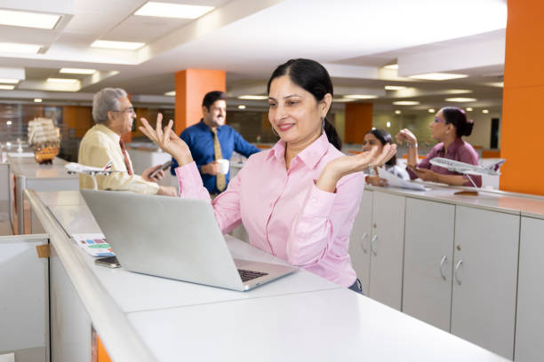 Happy businesswoman using laptop in office.