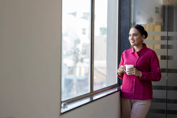 istock Smiling thoughtful businesswoman looking through window. 1433286493