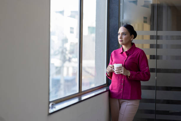istock Smiling thoughtful businesswoman looking through window. 1433286502