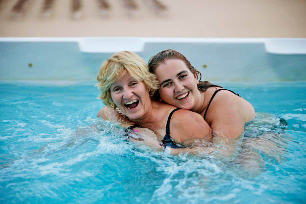 candid vacation portrait of mother and daughter in swim spa - vacations two generation family caucasian friendship imagens e fotografias de stock