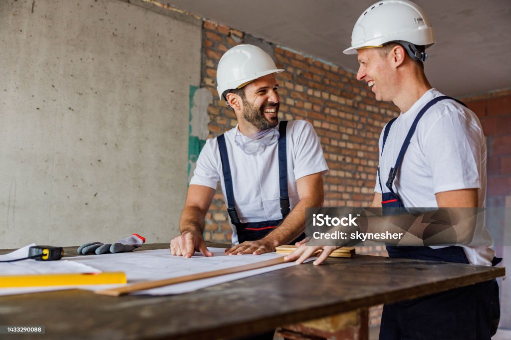 Construction Worker Understanding Happy Construction Workers Talking While Analyzing Blueprints At ...