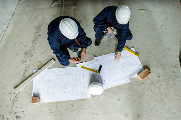 istock Above view of construction workers analyzing blueprints at renovation site. 1433290469