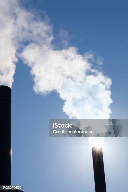 Two Chimneys With Smoke In The Blue Sky Stock Photo - Download Image Now - Smog, Carbon Dioxide, Chimney