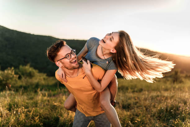 istock Young cheerful couple having fun while piggybacking in nature. 1433290759
