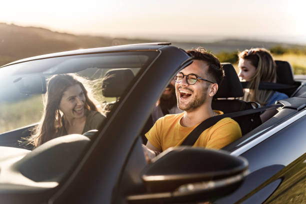 istock Young happy friends having fun while going on a road trip by convertible car. 1433290790