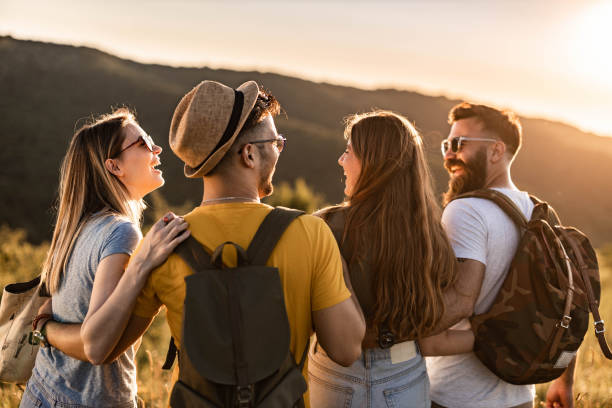 istock Rear view of happy friends communicating while walking on a hill. 1433292512
