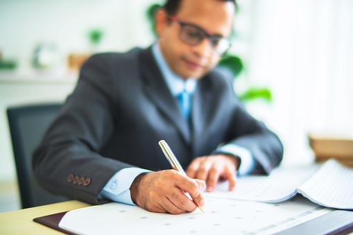 Businessman hand working and writing on calendar plan using  pen