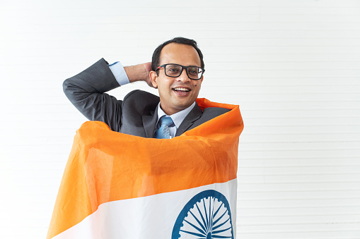 Happy businessman with indian flag while watching football match