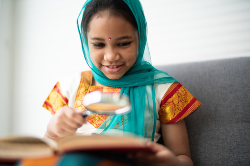 Young indian girl reading a book