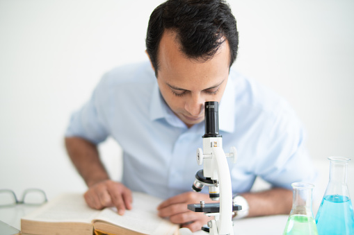 Indian Man Looking In microscope and research