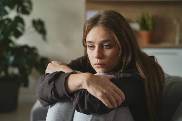istock Caucasian sad woman sitting at the sofa with depression 1433295336