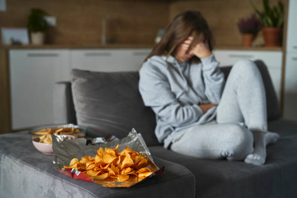 Caucasian woman has a problem with bulimic and sitting at the couch at home stock photo
