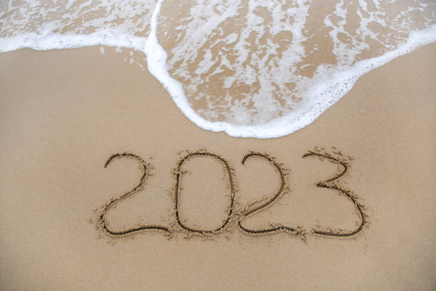 istock 2023 year written on sandy beach sea. Top view. Flat lay. 1433295797
