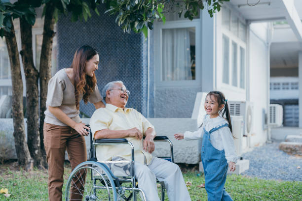 grand-père âgé handicapé en fauteuil roulant avec petit-enfant et mère dans le parc, famille asiatique multigénérationnelle heureuse s’amusant ensemble dans la cour arrière, grand-père âgé et petit enfant souriant et riant. - sociology photos et images de collection