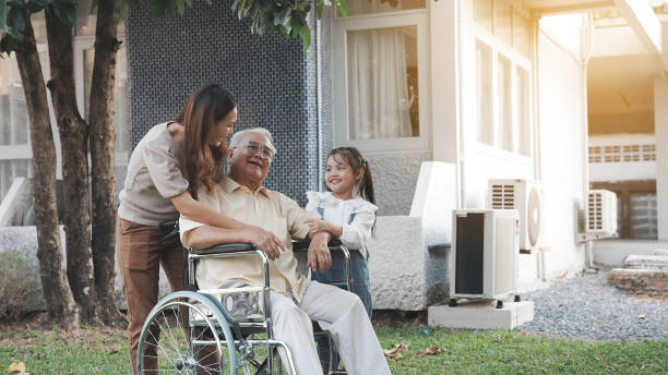 nonno anziano disabile su sedia a rotelle con nipote e madre nel parco, famiglia asiatica felice multi generazione che si diverte insieme all'aperto nel cortile, nonno anziano e bambino piccolo che sorride e ride. - grandmother action senior adult grandparent foto e immagini stock