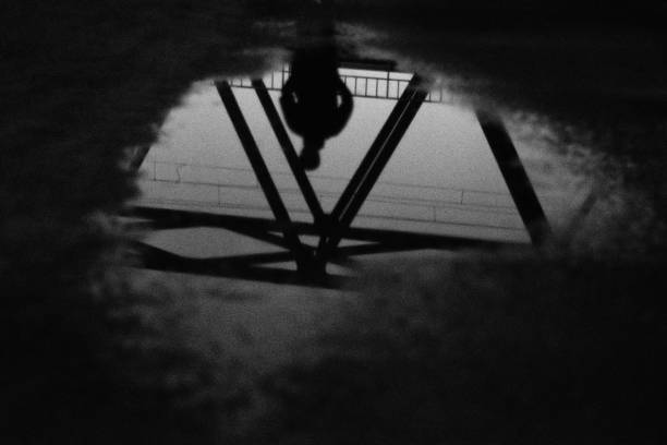 Silhouette of a person reflected in a puddle