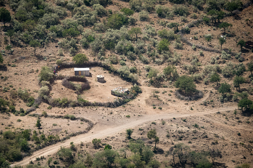 Somewhere in the land of the Masai, Kenya - March 24th 2022. Picture taken from airplane showing a typical Masai tribe farmhouse with suroundings. The tin shacks are used as residential buildings as well as to house lifestock.