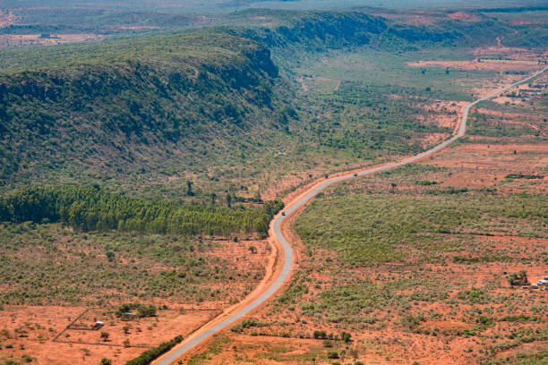 vista aérea de una cresta cubierta de arbustos del gran valle del rift, paralela a una carretera principal que conduce al norte hacia nairobi, kenia - valle del rift fotografías e imágenes de stock