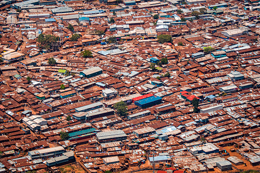 Nairobi, Kenya - March 24th 2022. Areal shot of the Kibera slum, Africas largest slum in the heart of Nairobi, taken from an airplane. Some incidental people visible on the dirt roads.