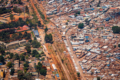 Nairobi, Kenya - March 24th 2022. Areal shot of the Kibera slum, Africas largest slum in the heart of Nairobi, taken from an airplane. Some incidental people visible on the dirt roads.