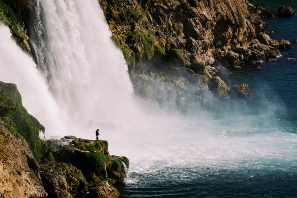 istock A man fishing in a place where the waterfall falls. 1433301363