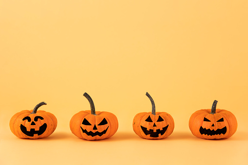 Pumpkin halloween characters in a row on orange colored background