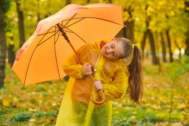 istock happy kid catching rain drops in Autumn park 1433305155