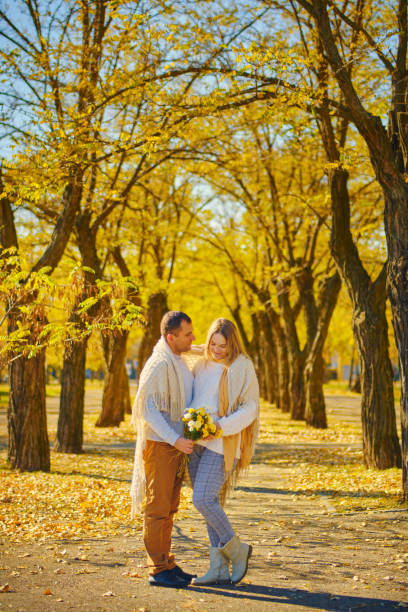 pregnant woman and man at sunny warm autumn park - human pregnancy couple prenatal care heterosexual couple imagens e fotografias de stock