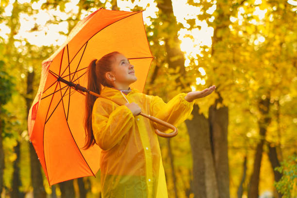 istock happy kid catching rain drops in Autumn park 1433306295