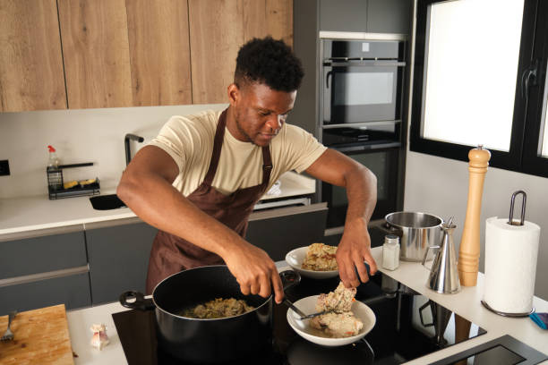 istock Young african man preparing fried chicken mince with vegetables recipe. 1433310772