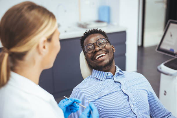 man having teeth examined at dentists. - dentists chair fotos imagens e fotografias de stock