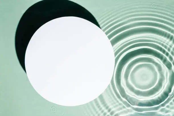 White circle copy space in transparent fresh green blue water drop splashing gel surface with flecks, waves, shade. Health care relaxation. Vacation coast sea natural concept. Flat lay. Place for text