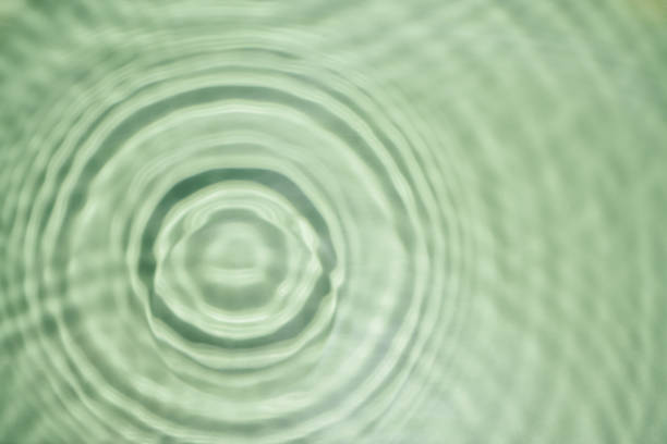 istock Defocused rippled transparent green water gel with concentric expanding circles on surface from fallen drop with waves 1433312044