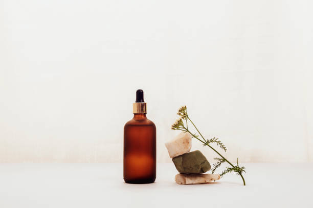 Brown cosmetic oil or serum bottle and yarrow flower on white background. Natural cosmetics, spa and wellness concept Brown cosmetic oil or serum bottle and yarrow flower on white background. Natural cosmetics, spa and wellness concept. massage oil photos stock pictures, royalty-free photos & images