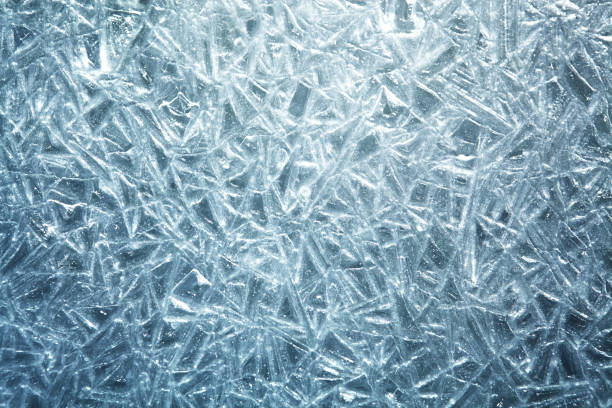 The texture of the ice surface. Winter background, festive background in the form of ice crystals, in natural deep blue color.