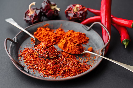 The picture shows a pile of small, red, very hot and spicy chilli peppers on an asian market.